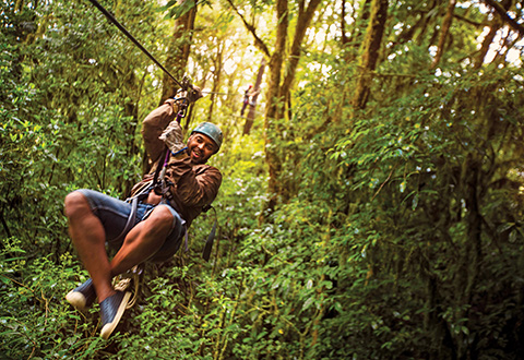 Man ziplining in jungle