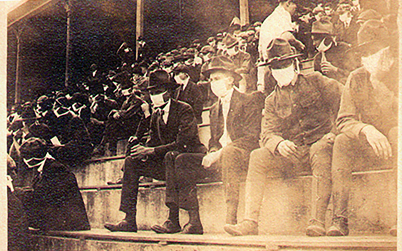 Picture of fans sitting with masks on during the 1918 epidemic watching football