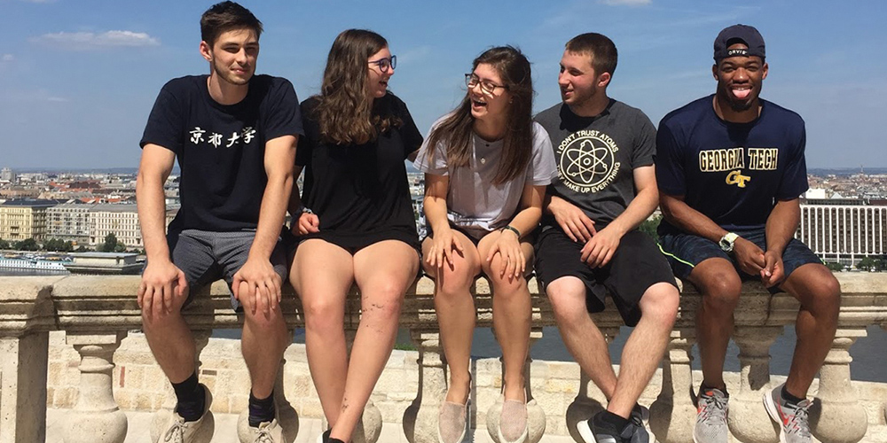 Students sitting on a wall ledge